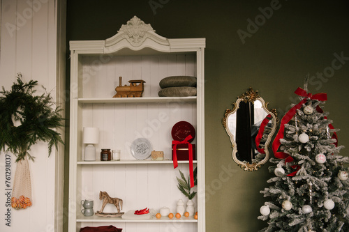 Obraz na płótnie Stylish interior with a white sideboard and a Christmas tree decorated for the new year w salonie