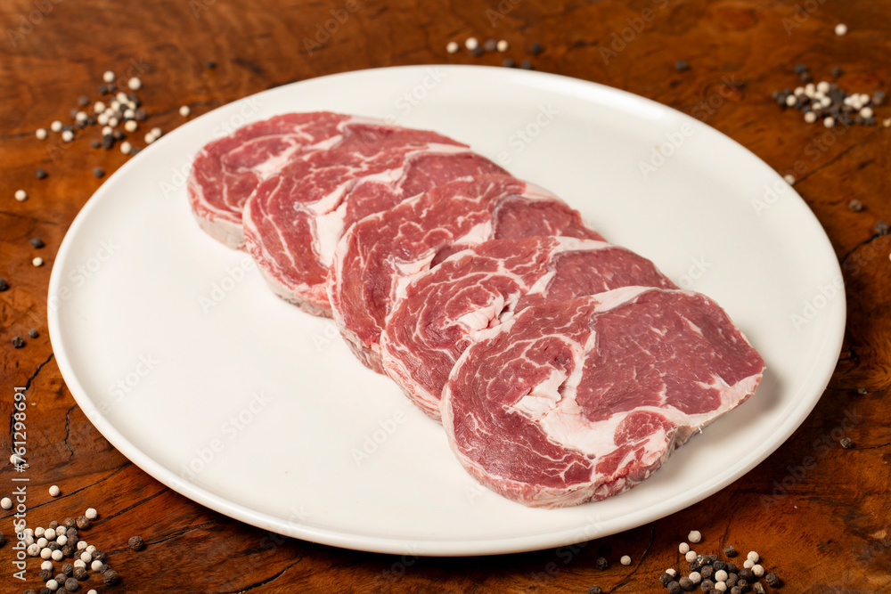 Raw beef ribeye meat. Butcher products. Fresh beef ribeye meat on dark background Raw beef ribeye meat. Butcher products. Fresh beef ribeye meat on dark background