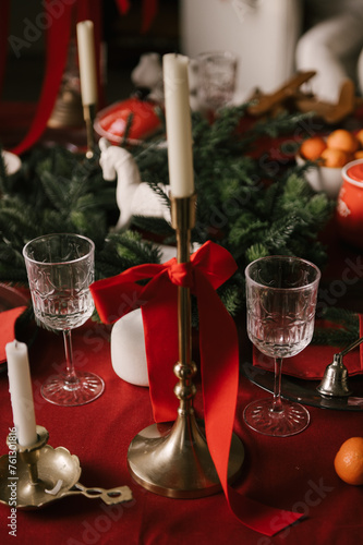 Obraz na płótnie Beautiful New Year decor, a Christmas table with a red tablecloth and candles, festive dishes and glasses w salonie