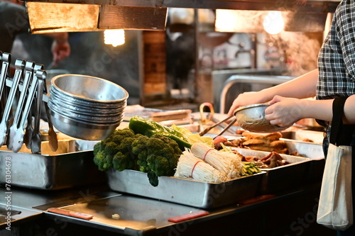 At a braised food stall in Nanjichang Night Market, this close-up shows customers choosing dishes with various ingredients available. photo