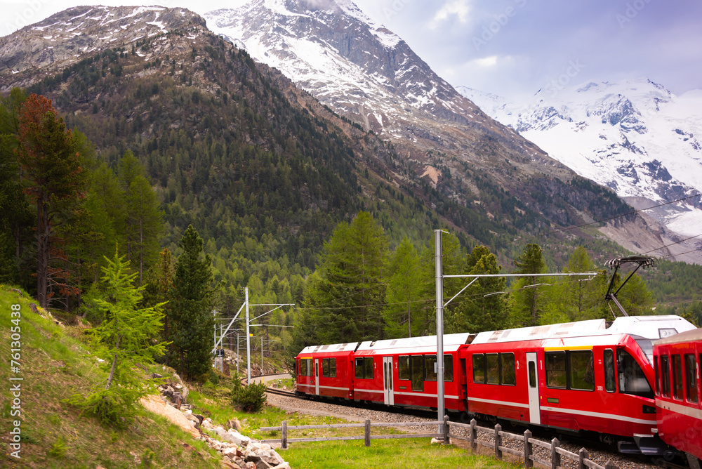 Red Swiss train moving in mountain landscape