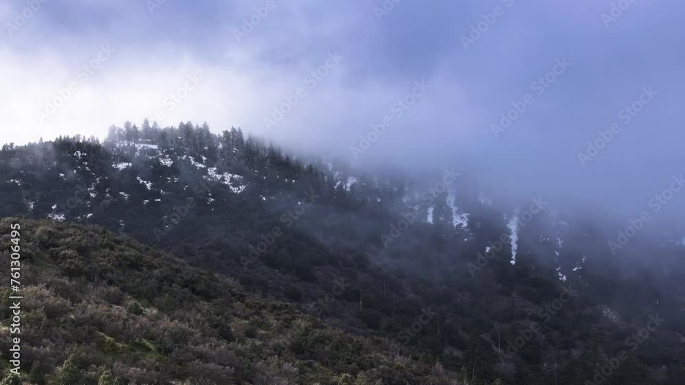 dramatic cloud coverage moving swiftly over the snow covered pine forest mountains of frazier park southern california 60fps dramatic cloud coverage moving swiftly over the snow covered pine forest mountains of frazier park southern california 60fps