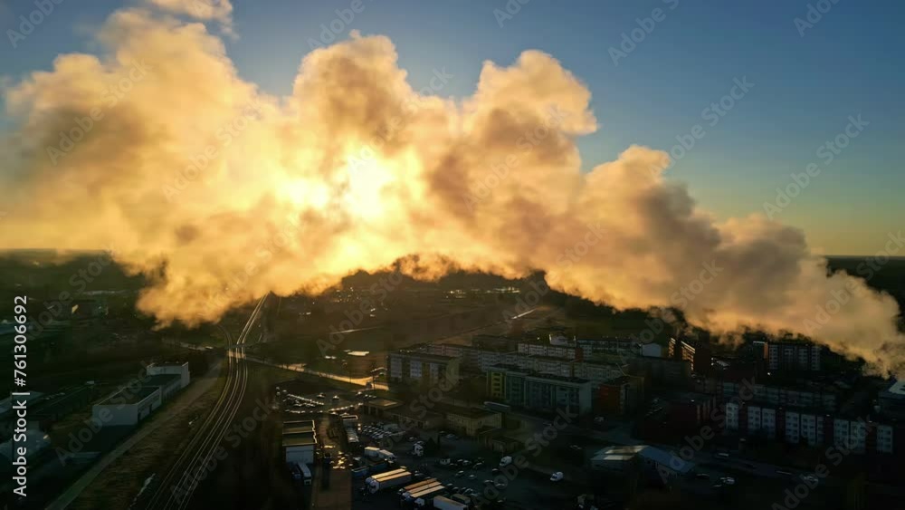 Steaming chimney vapour emissions floating across factory refinery during sunset aerial drone footage Steaming chimney vapour emissions floating across factory refinery during sunset aerial drone footage