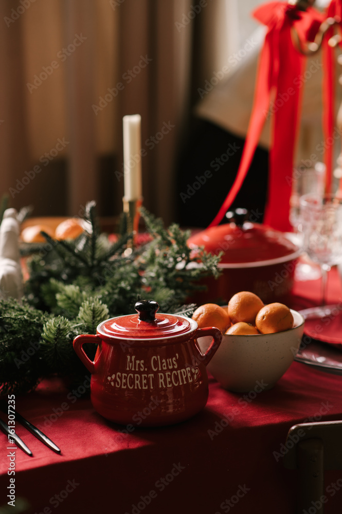 Beautiful New Year decor, a Christmas table with a red tablecloth and candles, festive dishes and glasses