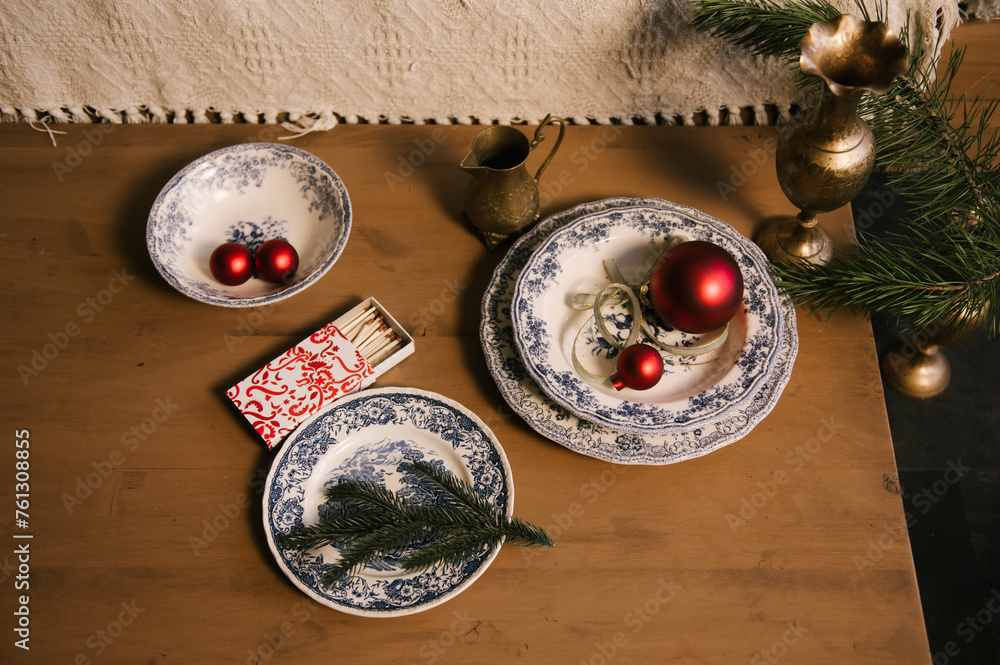 Beautiful New Year decor, red balls in vintage plates and gold candlesticks