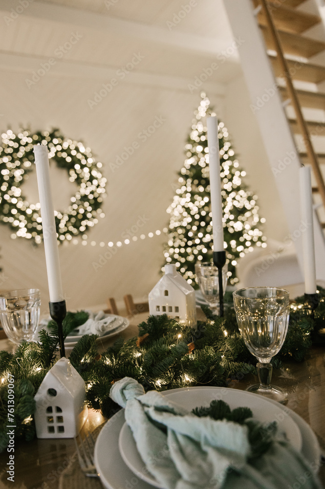 Beautiful New Year's decor at home, the table is set for the holiday against the background of the lights of the Christmas tree