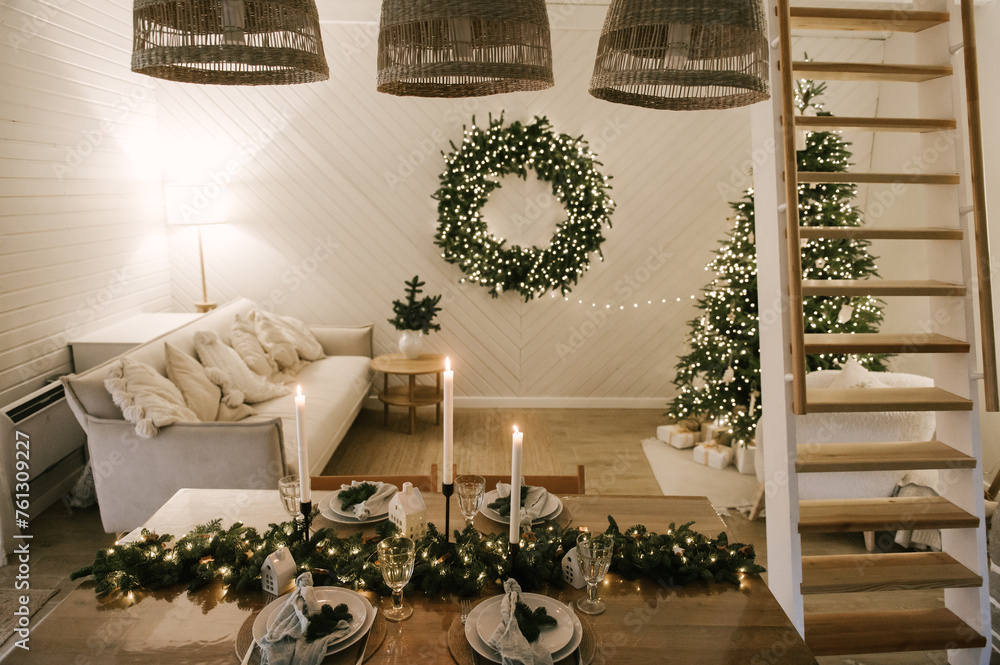 Beautiful New Year's decor at home, the table is set for the holiday against the background of the lights of the Christmas tree