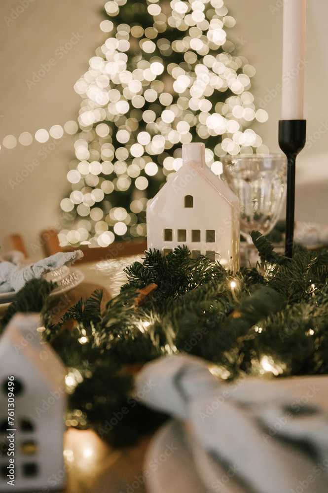 Beautiful New Year's decor at home, the table is set for the holiday against the background of the lights of the Christmas tree