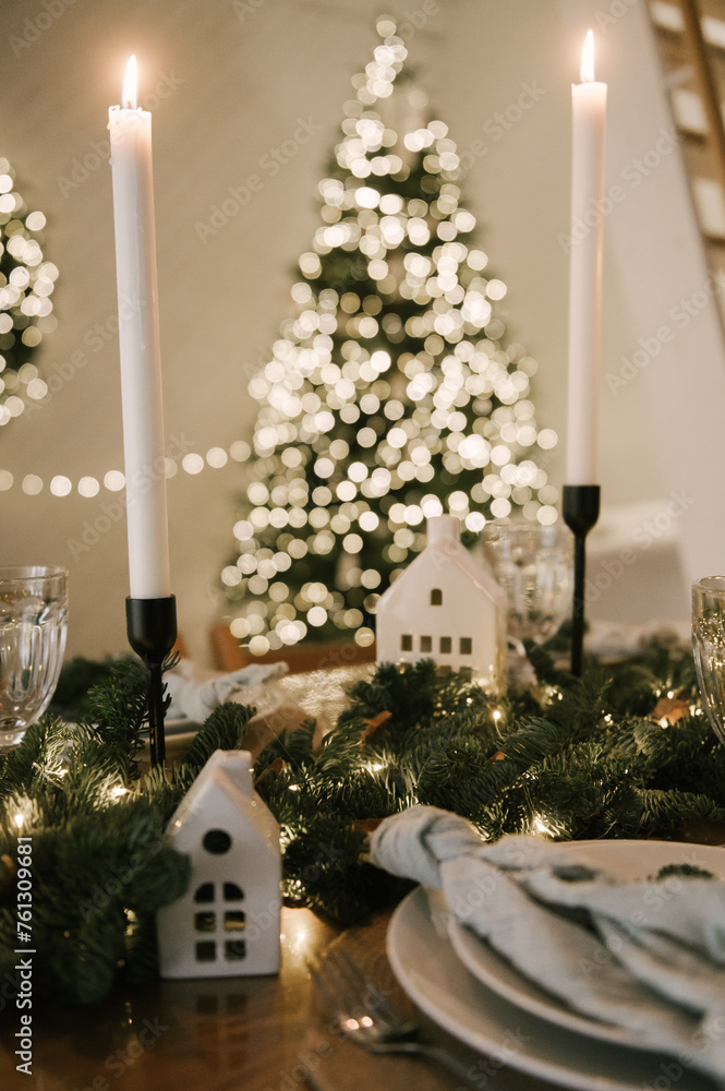 Beautiful New Year's decor at home, the table is set for the holiday against the background of the lights of the Christmas tree