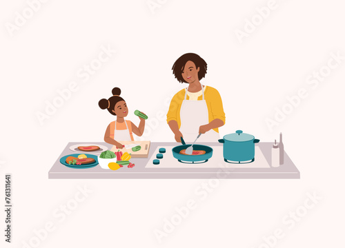 Black Mother And Daughter Preparing Food Together In The Kitchen. Smiling Black Little Daughter In Apron Cutting Cucumber With Knife. Mother Cooking Steak With Frying Pan. Half Length.