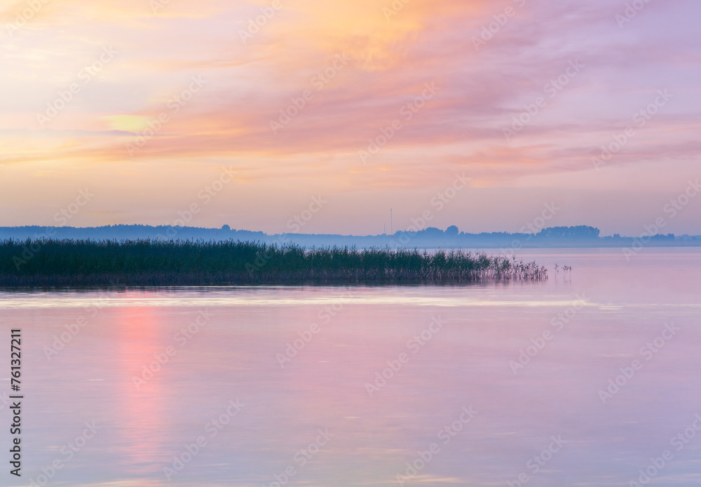 Lake sunset misty view with sunlight path on water surface (Svityaz, Ukraine)