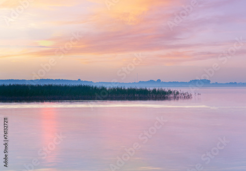 Lake sunset misty view with sunlight path on water surface  Svityaz  Ukraine 