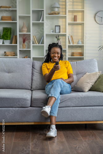 Young african american woman sitting on the sofa at home