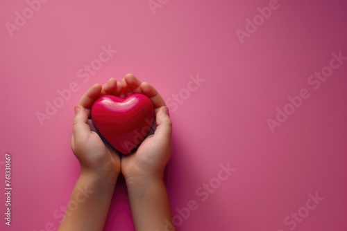 close-up, photo from above, child's hands holding a beautiful bright pink red heart. pastel pink background. Love, childhood, gift. Good. Postcard. Mothers Day.