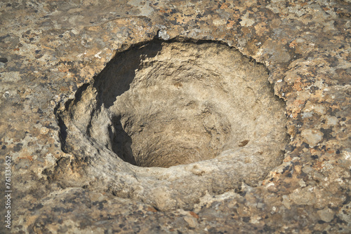 Big hole in a rock used as d water reservoirs in Gobustan reserve photo