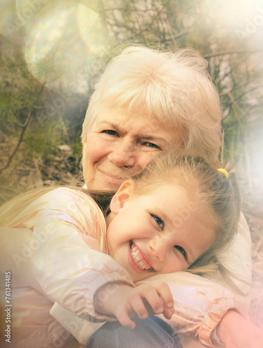Loving cute granddaughter hugging her grandmother. Happy family. Having good times with grandparent outdoors. Love, connection, bonding concept. Soft light toned