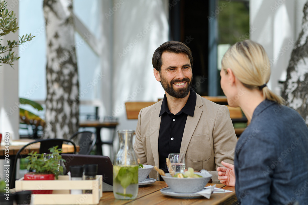 Business lunch for two managers, discussing new business project. Couple sitting outdoors on terrace restaurant, having dinner date. Business lunch for two managers, discussing new business project. Couple sitting outdoors on terrace restaurant, having dinner date.