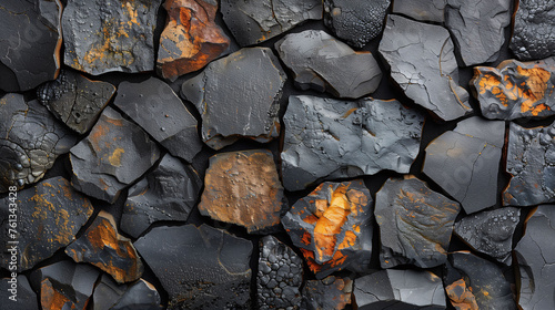 Close-up texture of a dark volcanic rock wall with varying shades and rust-colored accents.