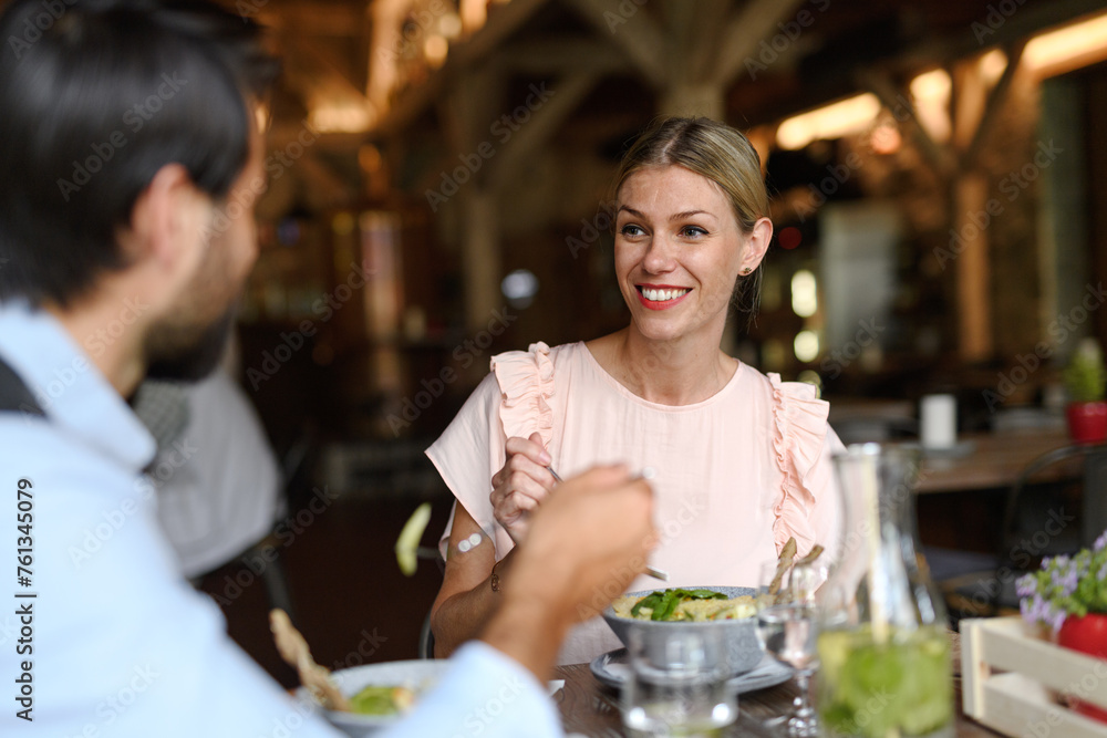 Happy loving couple at date in restaurant. Husband and wife sitting at table, laughing, having lunch in modern cafe. Happy loving couple at date in restaurant. Husband and wife sitting at table, laughing, having lunch in modern cafe.