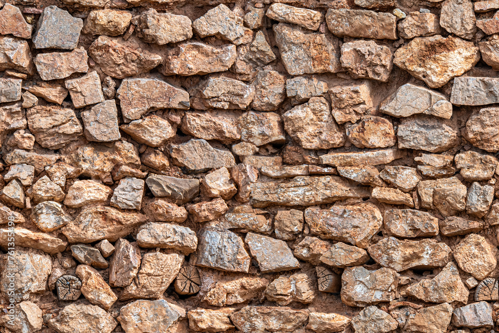 Fototapeta premium tileable background of old construction stone wall with stones, mud and logs