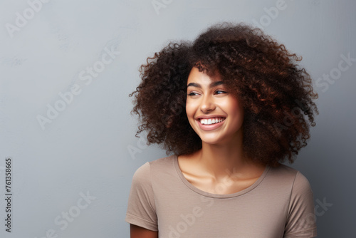 Woman with curly hair is smiling and looking at camera © vefimov