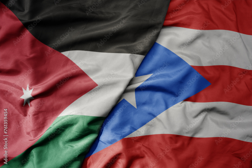 Fototapeta premium big waving national colorful flag of puerto rico and national flag of jordan.