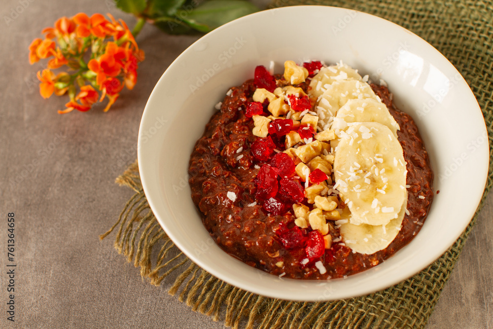 Healthy breakfast with oatmeal, cocoa, bananas, nuts and red fruits Healthy breakfast with oatmeal, cocoa, bananas, nuts and red fruits