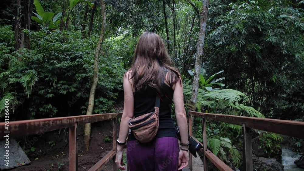 Woman walking little bridge in the middle of the jungle. Bali, Indonesia. High quality FullHD slow motion footage. Woman walking little bridge in the middle of the jungle. Bali, Indonesia. High quality FullHD slow motion footage.