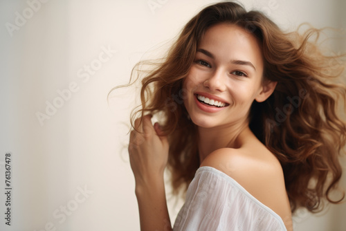 Woman with long brown hair is smiling and posing for picture