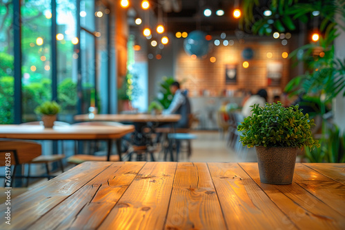 Wooden table with potted plant on the blurred coffee house background. © Iryna