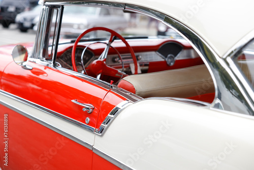 A shiny vintage red and white car park at the streets of California