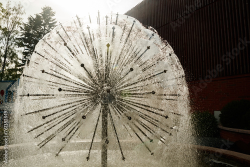 Waterdrops of beautiful ball fountain in summer park. photo