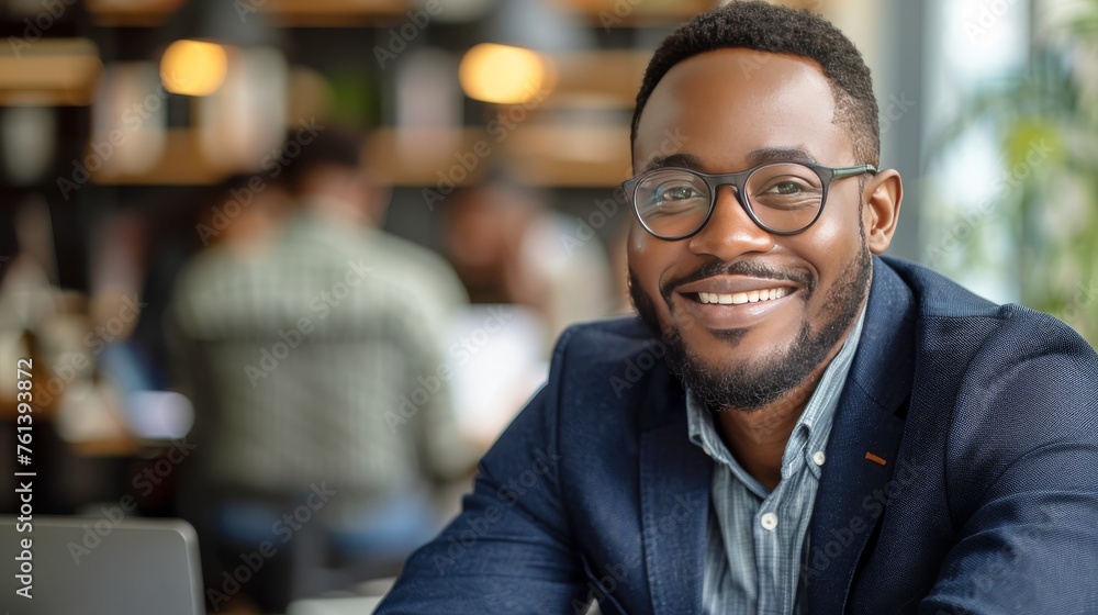 Man With Glasses Sitting at Table With Laptop