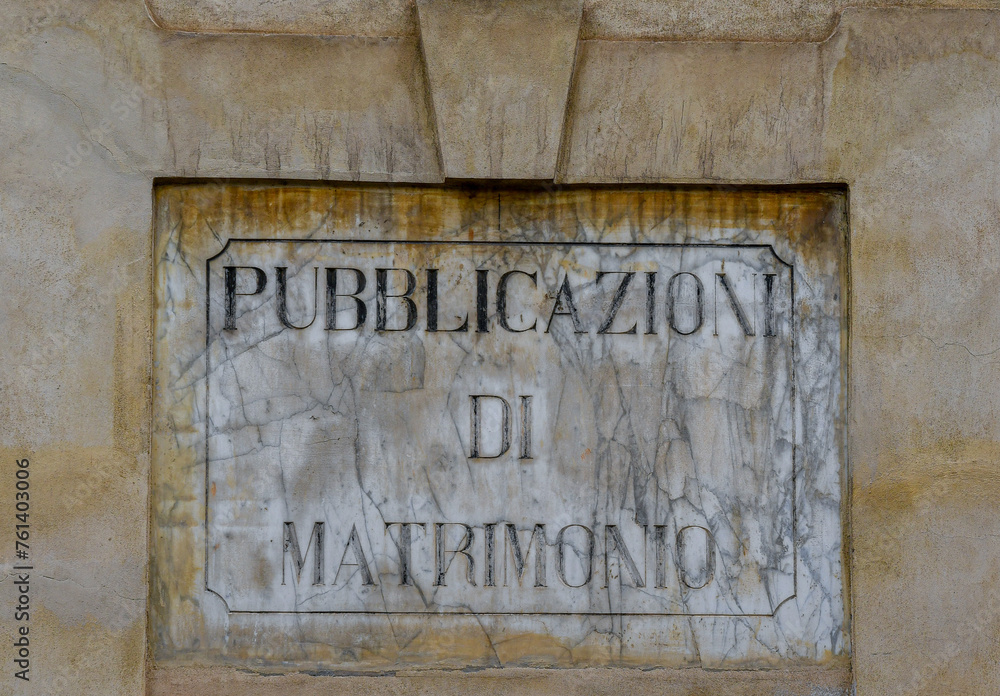 Close-up of a marble sign worn out by time that says: 
