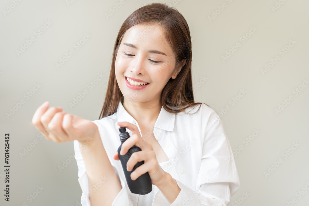 Perfume of essential aroma, beauty fashion concept. attractive perfect asian young woman hand holding perfume bottle, using spray and applying fragrance, scent at wrist on body, isolated on background Perfume of essential aroma, beauty fashion concept. attractive perfect asian young woman hand holding perfume bottle, using spray and applying fragrance, scent at wrist on body, isolated on background