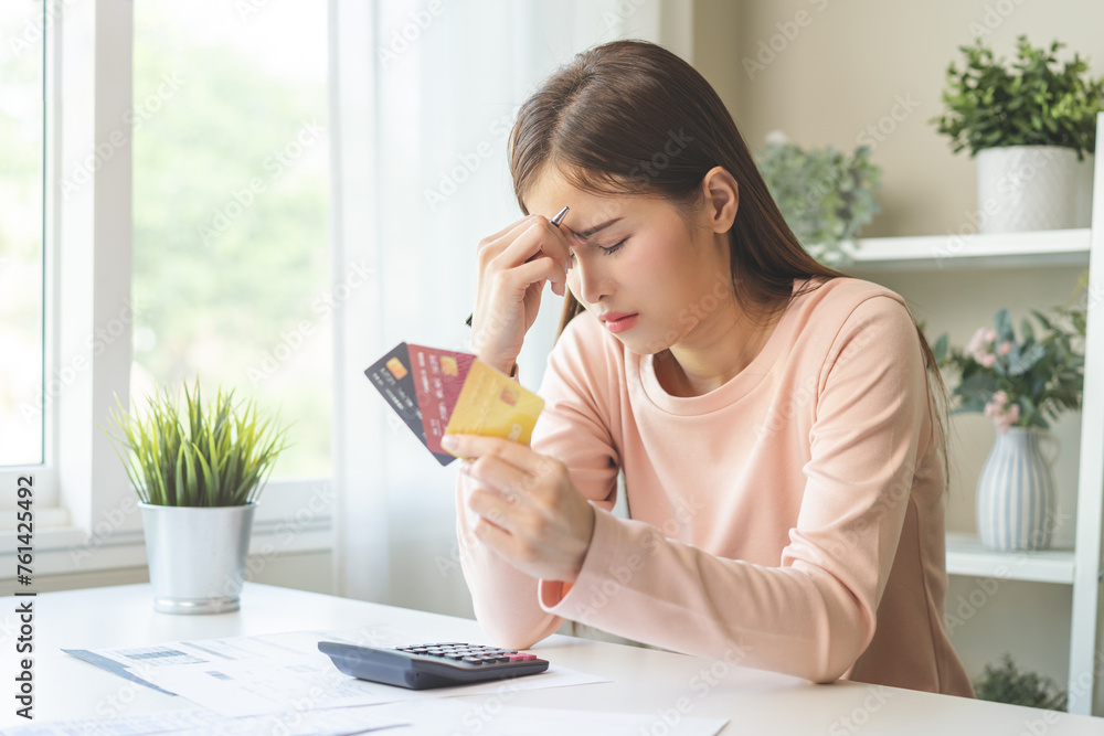 Financial owe, stressed asian woman, girl hand holding credit card, stressed by calculate expense from invoice or bill, no money to pay, mortgage or loan on table at home. Debt, bankruptcy or bankrupt Financial owe, stressed asian woman, girl hand holding credit card, stressed by calculate expense from invoice or bill, no money to pay, mortgage or loan on table at home. Debt, bankruptcy or bankrupt