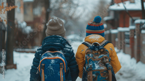 Back view of kids with backpack walking to school in winter