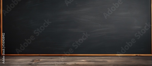 A rectangular blackboard with a wooden frame lays on the hardwood flooring under a cumulus cloudfilled sky, blending with the natural landscape