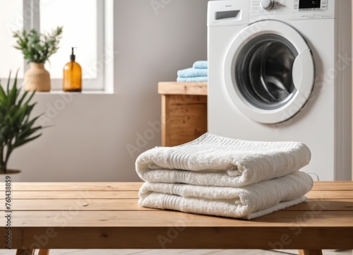 Empty wooden board with towels on blurred background of washing machine in home laundry.