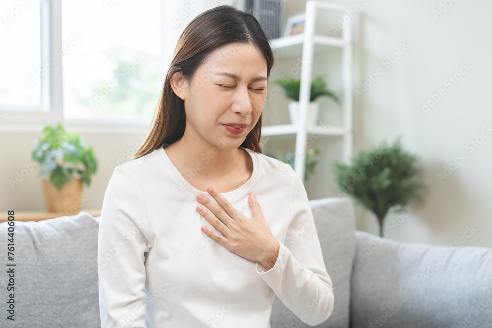 Acid reflux disease, suffer asian young woman have symptom gastroesophageal, esophageal, stomach ache and heartburn pain hand on chest from digestion problem after eat food, Healthcare medical concept Acid reflux disease, suffer asian young woman have symptom gastroesophageal, esophageal, stomach ache and heartburn pain hand on chest from digestion problem after eat food, Healthcare medical concept