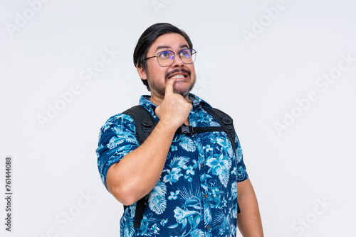 Canvas Print Middle-aged man in a tropical shirt gestures to an oops moment biting his finger awkwardly, showing realization and regret