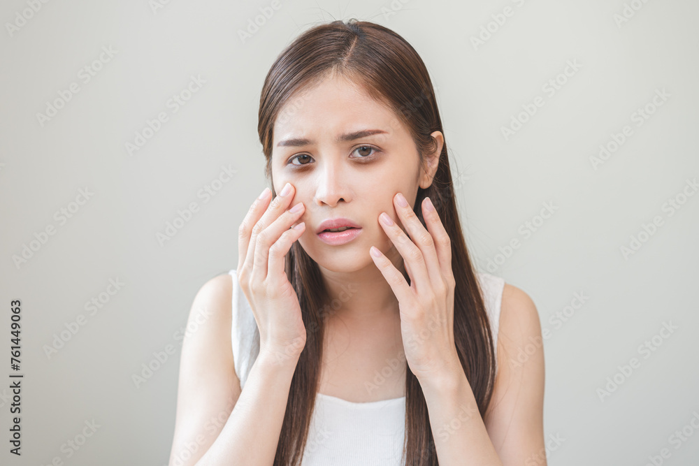 Bored, insomnia asian young woman, girl looking at camera, hand touching under eyes with problem of black circles or panda puffy, swollen and wrinkle on face. Sleepless, sleepy healthcare person. Bored, insomnia asian young woman, girl looking at camera, hand touching under eyes with problem of black circles or panda puffy, swollen and wrinkle on face. Sleepless, sleepy healthcare person.