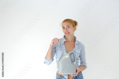Smiling woman holding detergent bottle for machine wash. Isolated studio portrait on white.