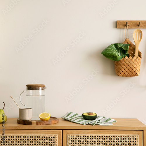 Warm and cozy interior design of kitchen space with rattan commode, ladder, hanger on the wall, herbs, vegetables, pitcher, avocado, pears, food and kitchen accessories. Home decor. Template.