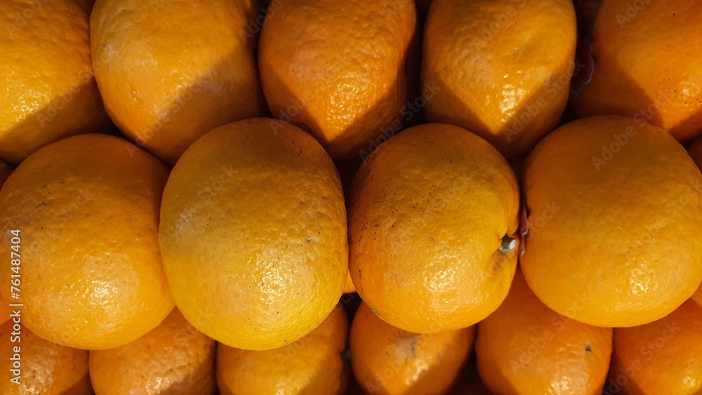 Close up pile of tasty fresh oranges sold at the market as a background.
