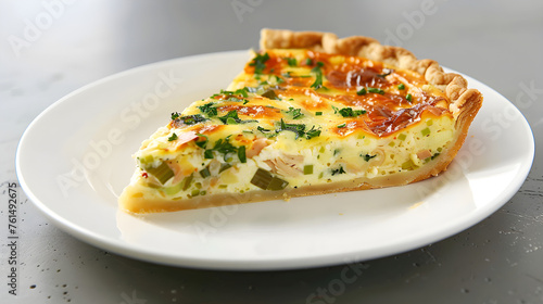 Freshly baked quiche slice on plate