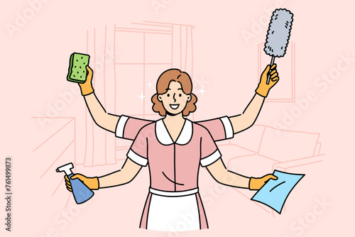Woman maid is ready to quickly clean apartment, working in multitasking mode thanks to presence of four hands. Girl maid stands in hotel room and holds items to perform high-quality cleaning