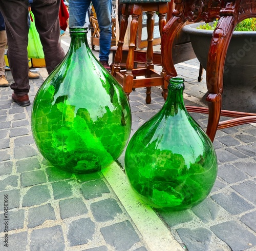evocative image of glass demijohns for wine at a vintage market in Italy
 photo