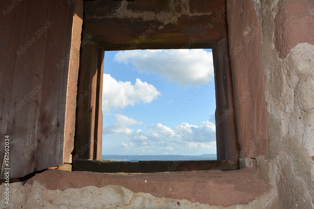 Fototapeta premium View through an old castle window on a blue sky