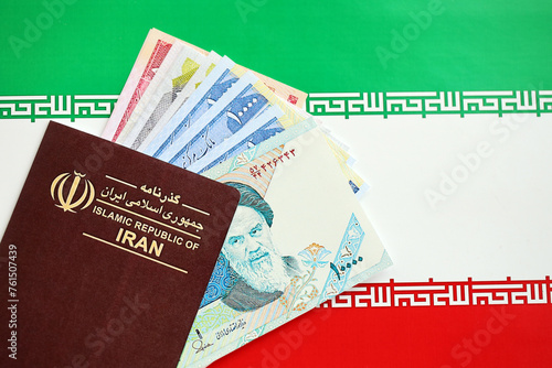 Red Islamic Republic of Iran passport and iranian reals money bills background close up. Tourism and travel concept photo